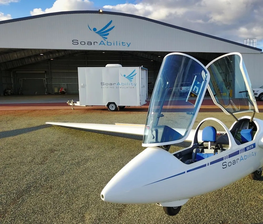 The SoarAbility Gliding Simulator trailer parked in front of the branded hangar at Cunderdin
